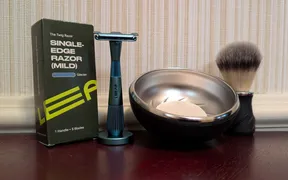Larry Shaves video thumbnail showing the Leaf Twig razor in Glacier light blue with matching stand