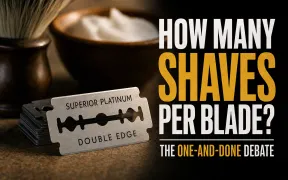 A double-edge safety razor resting on a shaving stand beside a stack of blade wrappers on a dark bathroom counter