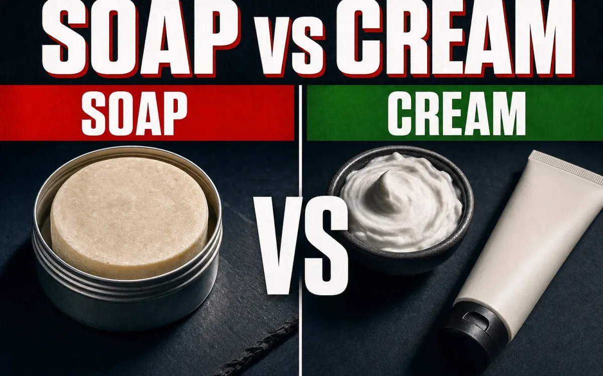 A split composition on a dark slate counter, a round artisan shaving soap puck in a tin on the left under a red SOAP banner, a tube and bowl of shaving cream on the right under a green CREAM banner, a white VS in the center, warm side-light, headline SOAP vs CREAM in white block letters across the top