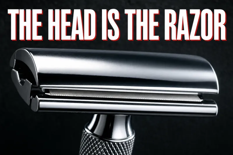 A dramatic macro photograph of a chrome double-edge safety razor head on dark slate, the domed top cap, exposed blade edge and smooth safety bar clearly stacked, knurled handle below, headline THE HEAD IS THE RAZOR in white block letters with a red drop shadow across the top