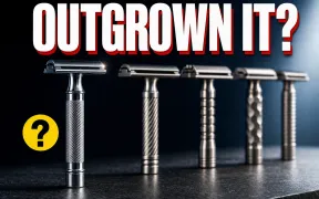 A plain chrome starter double-edge safety razor standing in sharp focus in the foreground on a dark slate counter, a blurred row of premium machined stainless razors lined up behind it, headline OUTGROWN IT? in white block letters with a red drop shadow across the top, a small yellow question-mark badge
