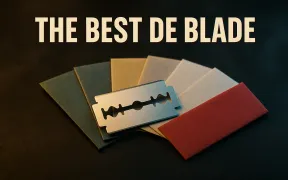 A fanned spread of double edge razor blades in plain paper wrappers on dark slate under the headline The Best DE Blade