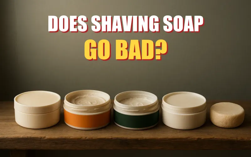 A row of shaving soap tubs and pucks of different ages and wear levels lined up on a bathroom shelf.