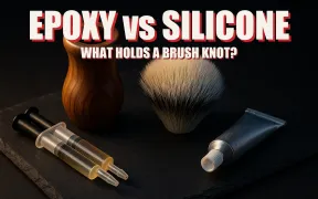 A shaving brush handle with its knot removed beside a loose synthetic knot, a two-part epoxy syringe, and a tube of clear silicone sealant on dark slate, headline EPOXY VS SILICONE in white block letters with a red drop shadow