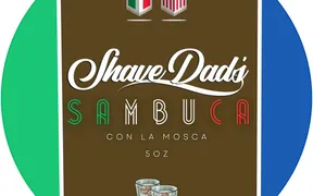 Sambuca Con La Mosca, Shave Dad × Strike Gold Shave holiday soap label, Italian and US flag bunting over two shot glasses with coffee beans